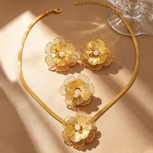 Close-up of golden filigree flower jewelry set with elegant white pearls on warm base.