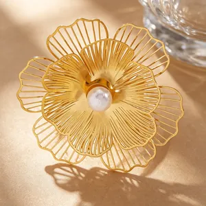 Detail macro view of an exaggerated golden filigree flower ring with center faux pearl