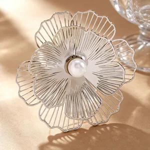 Close-up of silver hollowed flower jewelry featuring a central white imitation pearl