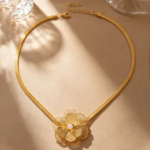 Detailed view of a gold-tone flower pendant necklace with an elegant pearl center.