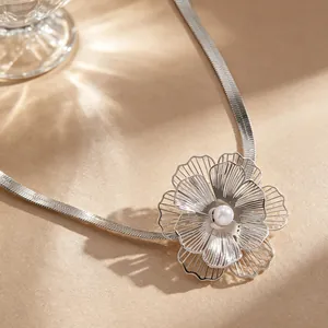 Detailed macro shot of an oversized silver floral necklace featuring a white pearl center