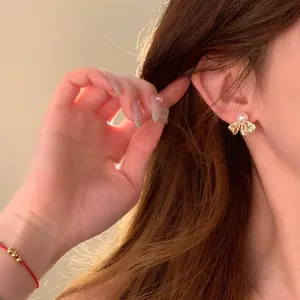 Close-up showing the elegant bow-shaped pearl earring worn on a female ear for a luxurious look