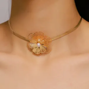 Close-up of elegant gold filigree flower choker necklace with pearl center detail.
