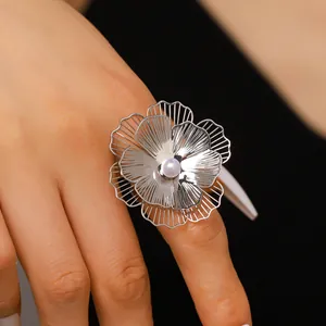 Close-up detail of an exaggerated silver wire flower ring with center faux pearl