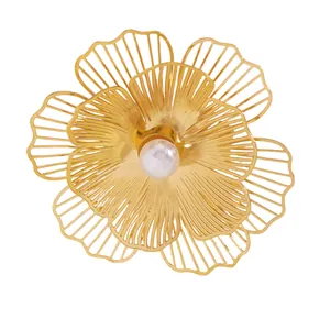 Close-up detail of a fashion golden hollow flower jewelry piece with a white pearl center