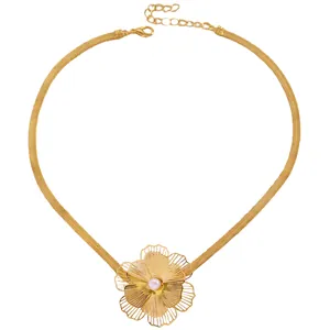 Close-up of gold snake chain necklace featuring a large layered flower with a central pearl bead