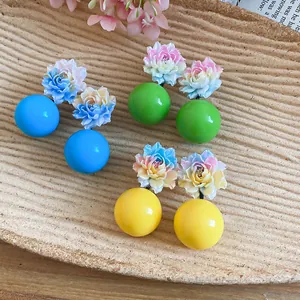 Close-up detail of colorful resin flower stud earrings for a sweet vacation style