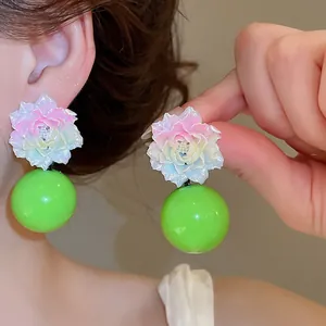 Detail view of sweet resin flower earrings with vibrant green spherical drops and silver pins.