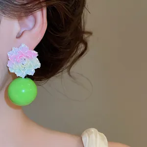 Detailed macro shot of dopamine style resin flower earrings featuring a bold green bead