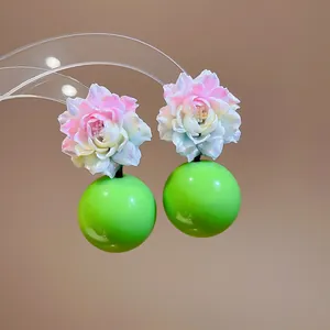 Macro detail of dopamine resin flower earrings featuring vibrant green round drops