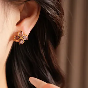 Primer plano de pendientes de trébol de cuatro hojas bañados en oro de 18k