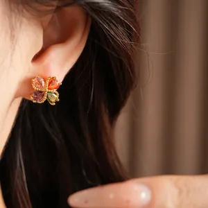 Vista detallada de pendientes de trébol con circonitas de colores chapados en oro 18k