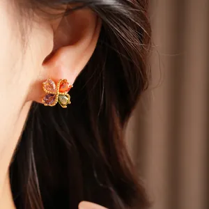 Primer plano de pendientes de trébol de circonita con forma de corazón en oro 18k
