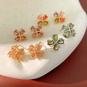 Primer plano de pendientes de trébol de circonita brillante en varios colores