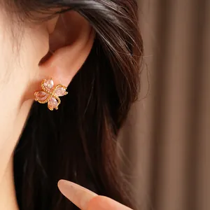 Primer plano de pendientes de trébol rosa puestos en la oreja