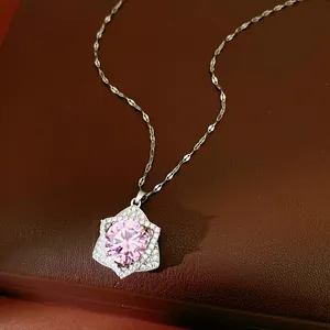 Close-up of a sparkling star pendant necklace with a large pink round zircon center stone.