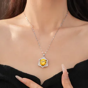 Detailed close-up of a sparkling yellow zircon star pendant necklace on a model's neck