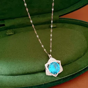 Close-up detail of a sparkling blue zircon star pendant necklace in a green velvet box
