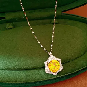 Close-up detail of a star pendant necklace with a brilliant yellow zircon in a green velvet box