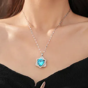 Elegant silver-toned necklace featuring a brilliant blue zircon star pendant shown on model