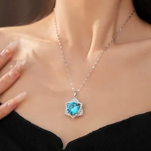Elegant sparkling blue zircon star pendant necklace close-up on model, silver color finish.