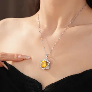 Close-up of shiny yellow zircon star pendant necklace worn by female model