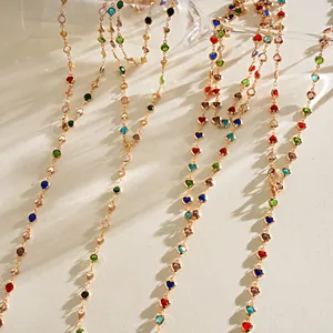Détail montrant des colliers dorés avec des cristaux en forme de cœur multicolores.