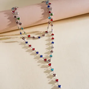 Gros plan d'un collier en chaîne argentée orné de breloques en cristal en forme de cœur coloré