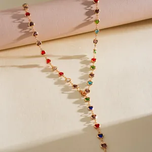 Vue détaillée d'un collier en Y doré avec des cristaux en forme de cœur colorés