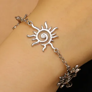 Dettaglio di un bracciale con ciondolo a sole in argento e cristallo sul polso.