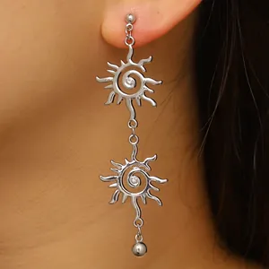 Dettaglio ravvicinato di un orecchino a spirale a forma di sole sull'orecchio del modello.