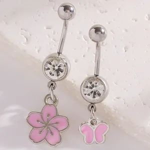 Close-up of pink enamel flower and butterfly belly rings with sparkling zircons