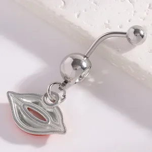 Detail view of silver curved navel piercing featuring a red lips pendant and clear stone