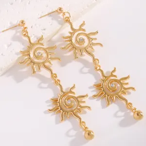 Dettaglio orecchini pendenti a forma di sole dorato con cristalli luminosi al centro