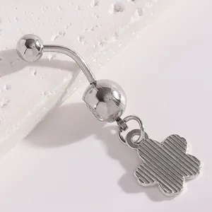 Macro detail of a silver stainless steel belly button ring with a striped flower pendant.