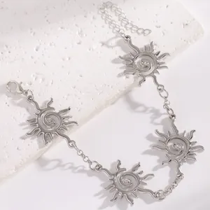 Dettaglio dei ciondoli a spirale solare in argento vintage con cristalli incastonati.