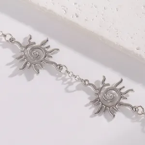 Primo piano di una collana a spirale con sole argentato e centri in strass