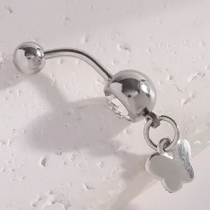 Macro detail of a silver belly button ring with butterfly charm and clear crystal