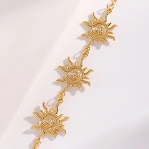 Dettaglio ravvicinato di una collana con ciondolo a spirale sole dorato e cristallo centrale