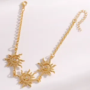 Dettaglio ravvicinato di pendenti a vortice solare dorati vintage con cristalli su collana