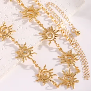 Dettaglio ravvicinato di una collana a catena con ciondoli a sole in oro e cristalli lucidi