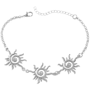 Dettaglio macro di un bracciale argento con ciondoli a spirale solare e cristalli.