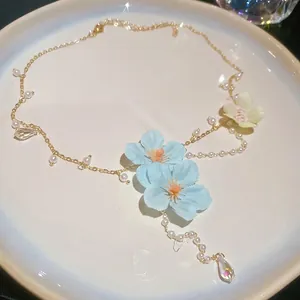 Close-up of elegant light blue fabric flower and pearl beaded necklace detail
