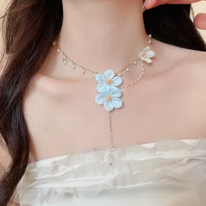 Close-up of fairy-style necklace with blue fabric flowers, pearls and crystal drops.