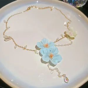 Close-up of a floral pearl necklace with light blue fabric flowers and crystal beads