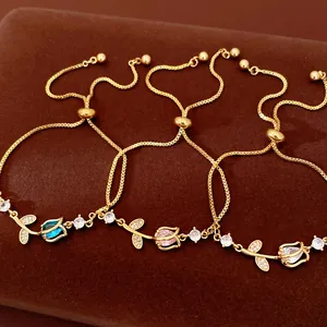 Macro detail of three elegant gold tulip flower bracelets featuring colorful zircon stones