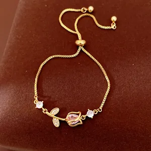 Detailed macro view of gold tulip flower bracelet with pink zircon and adjustable pull chain