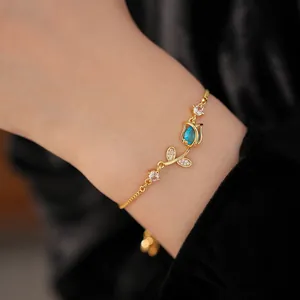 Close-up detail of the zircon tulip flower on the gold-toned adjustable bracelet