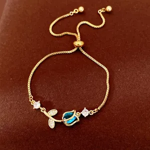 Elegant gold tulip bracelet featuring blue zircon petals and adjustable box chain