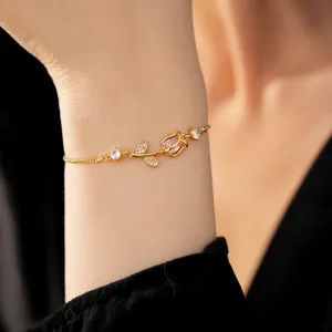 Close-up detail of a gold tulip bracelet with zircon stones worn on a delicate wrist.